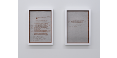 Two separate pieces of onion paper held with teak backings juxtaposed together. It is about the length of an arm. The two papers have a profile information of Vietnamese anti-colonialist Minh Khai in French with a red typewriter font, including the artist’s handwritten English notes beside.