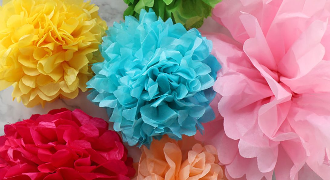 A photograph of six, colored tissues crafted into flower designs. Their colors are yellow, blue, pink red, orange, and green.