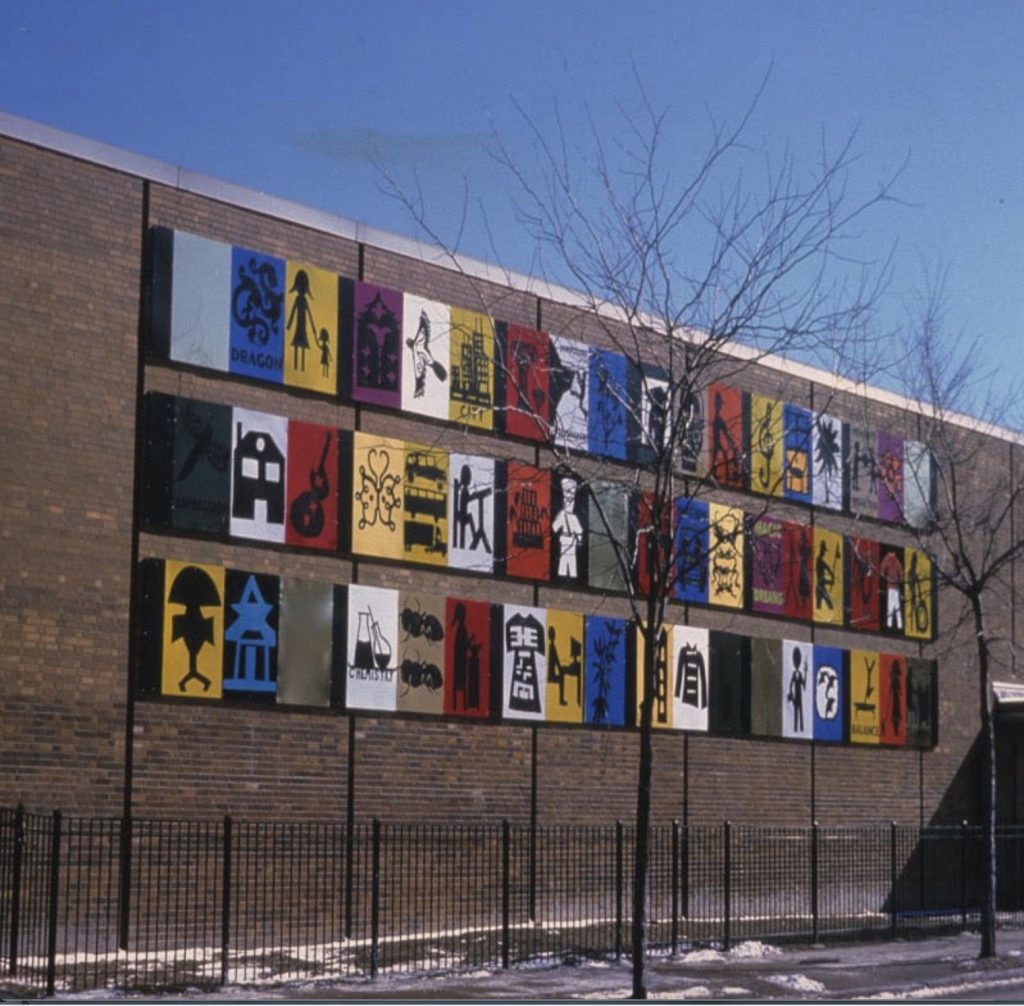 The side of a brick building with three separate rows of eighteen different color-blocked grid-style images including a dragon, a figure working at a desk, a house, and a skyscraper. 