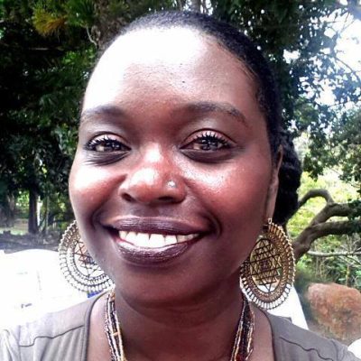 A young Black woman smiles into the camera.